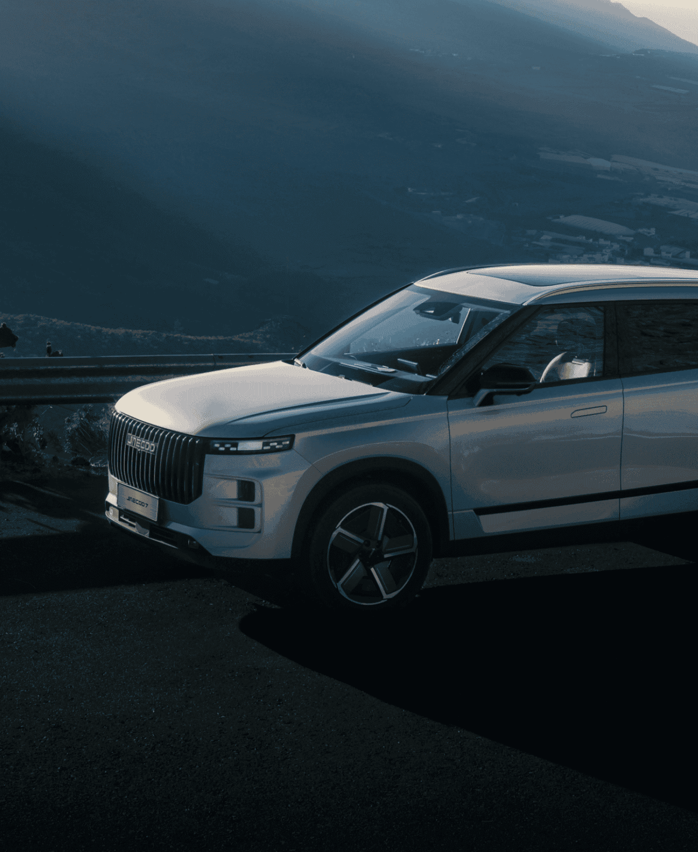 Close up of silver JAECOO driving in mountain area